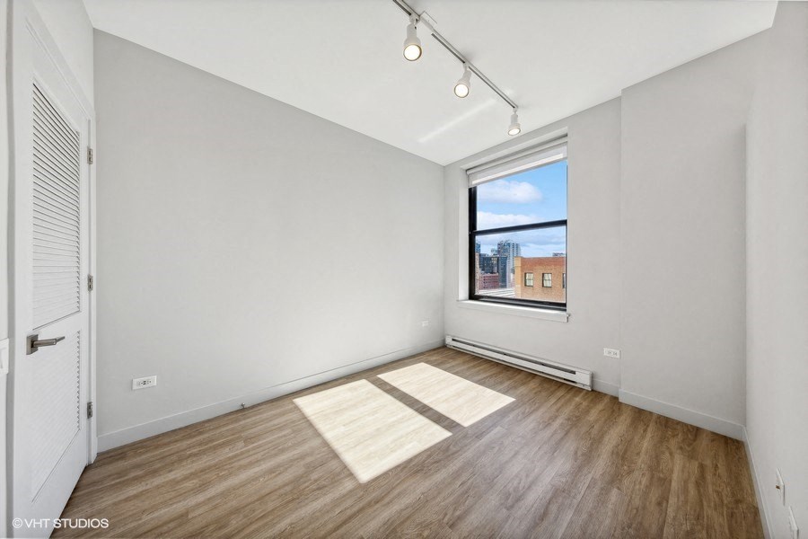 an empty living room with a window and wood floors