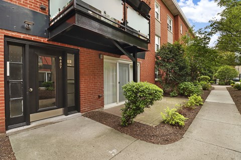 A red brick building with a black door and windows.