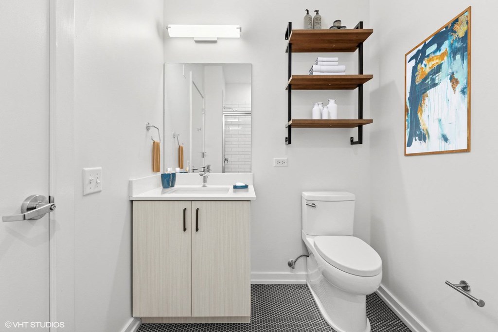 A bathroom with a white toilet, sink, and a cabinet.