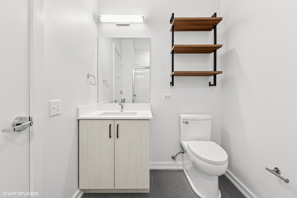 A white bathroom with a toilet, sink, and medicine cabinet.
