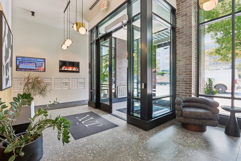 A glass door entrance to a building with a plant in front of it.