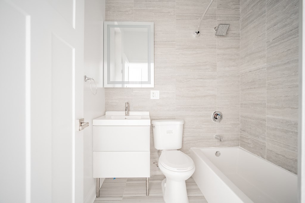 a white bathroom with a toilet and a tub and a sink