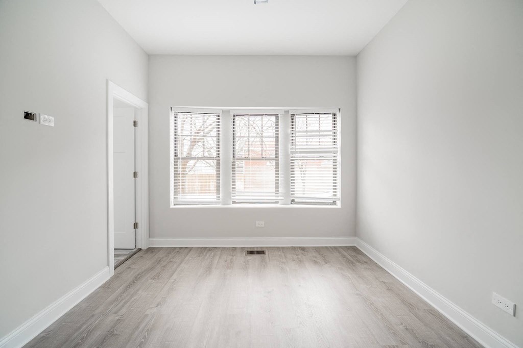 an empty room with white walls and a window