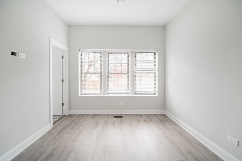 an empty room with white walls and a window