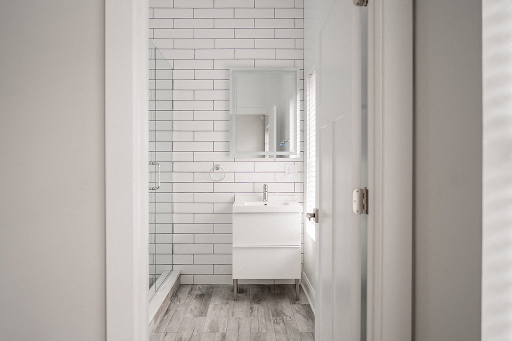 a small white bathroom with a sink and a mirror