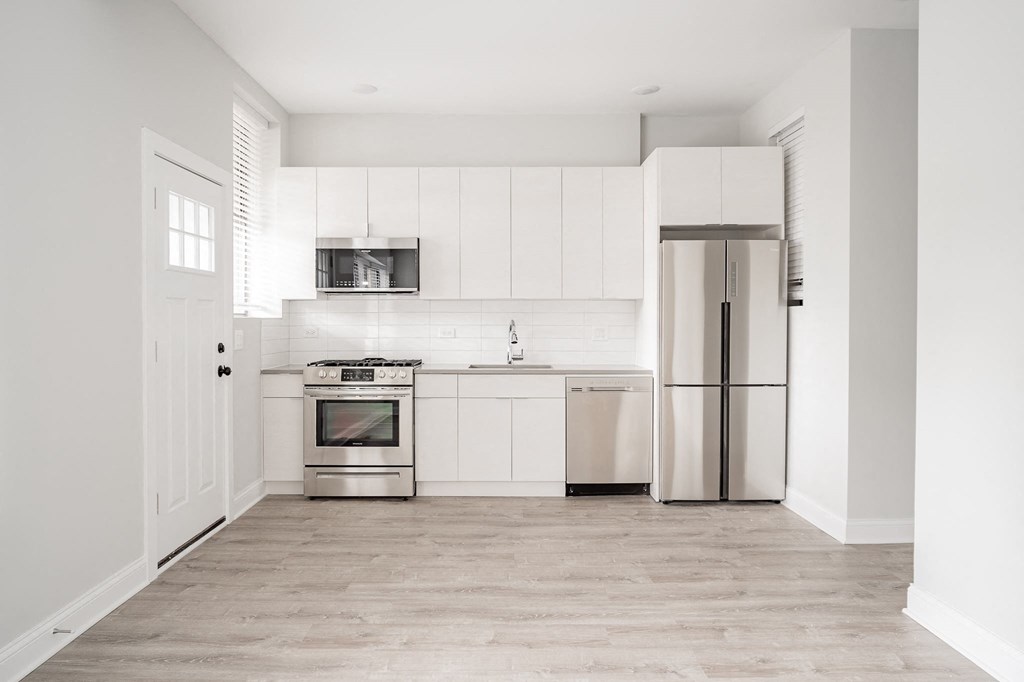 a white kitchen with stainless steel appliances and white cabinets