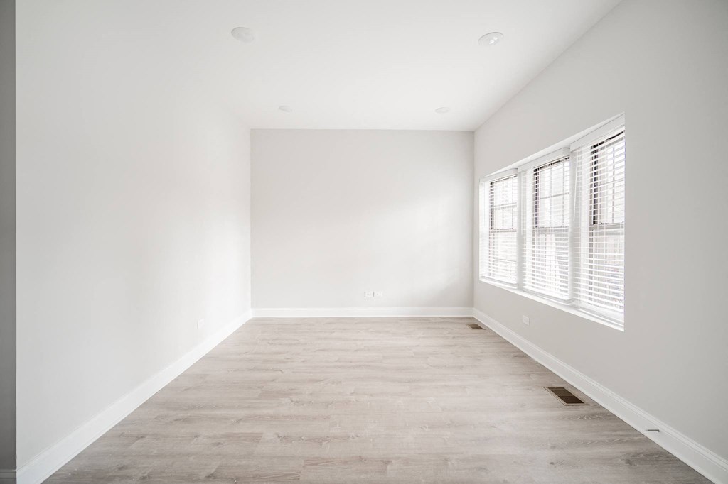 an empty room with white walls and a window
