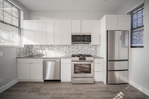 a kitchen with white cabinets and stainless steel appliances