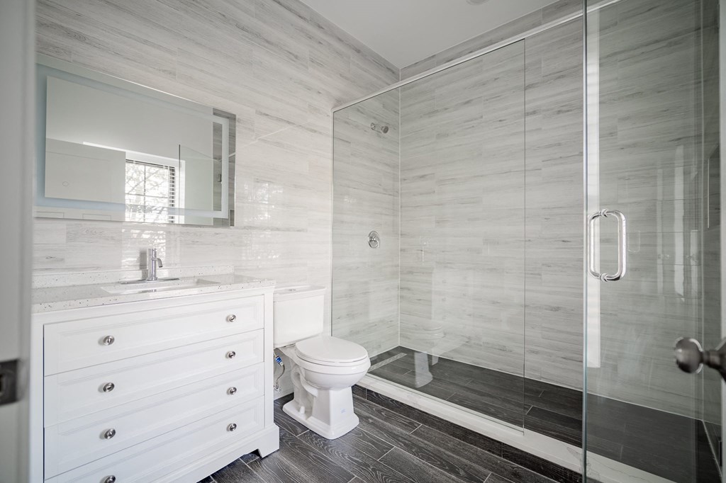 a white bathroom with a toilet and a shower