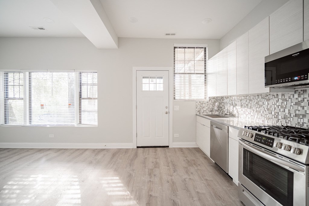a kitchen with white cabinets and stainless steel appliances