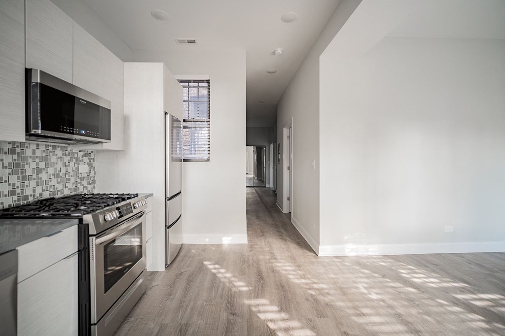 a kitchen with white cabinets and a stainless steel stove