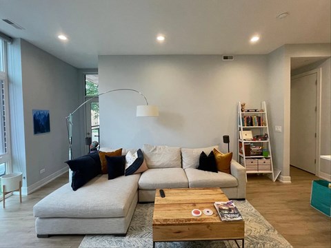 A living room with a white couch and a wooden coffee table.