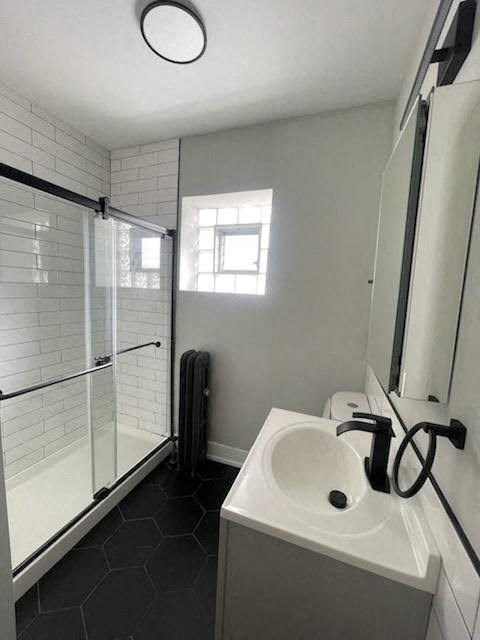a white bathroom with a sink and a shower