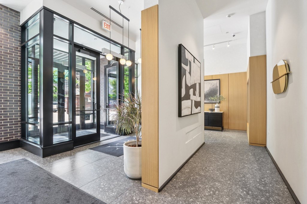 A hallway with a plant in a white pot and a framed picture on the wall.