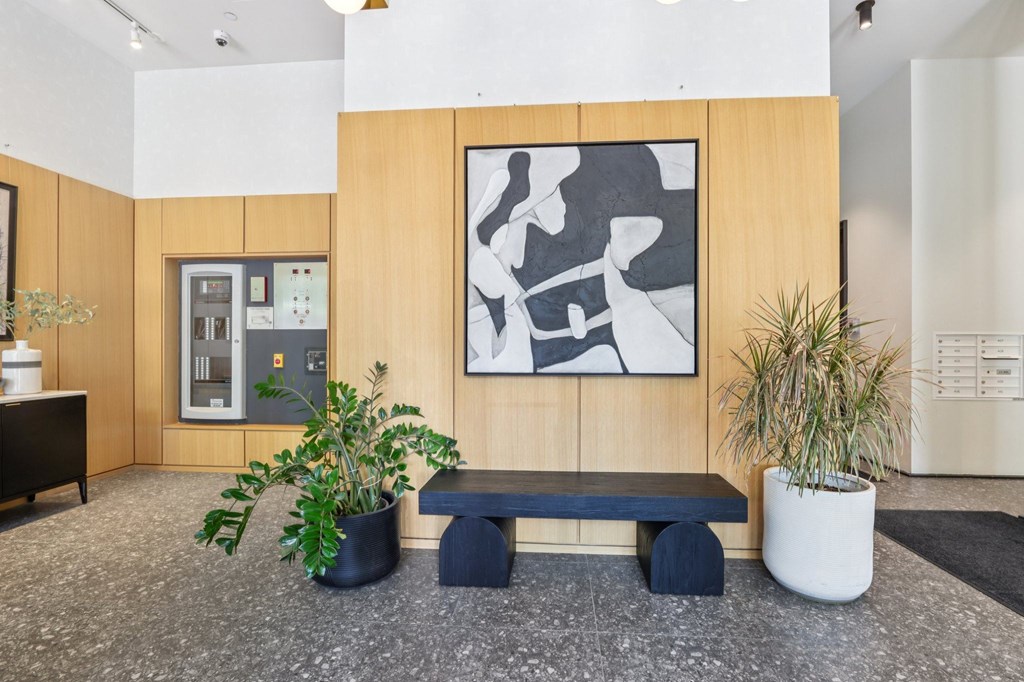 A modern office lobby with a large abstract painting on the wall.