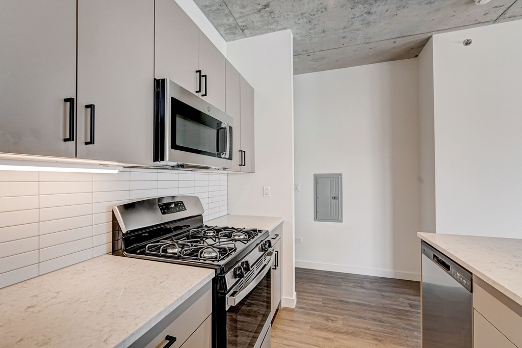 A kitchen with a stove, microwave, and oven.