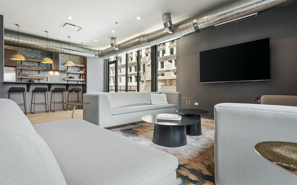 a living room with couches and a television and a bar