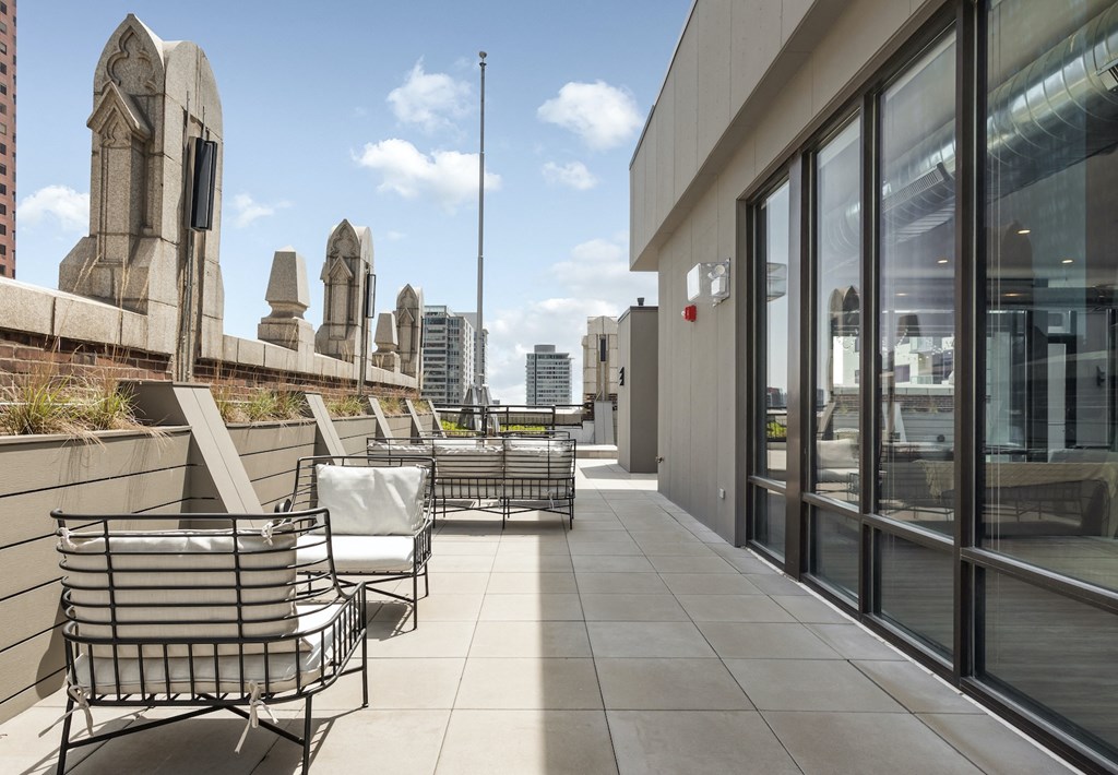the terrace of a building with chairs and tables and a view of the city