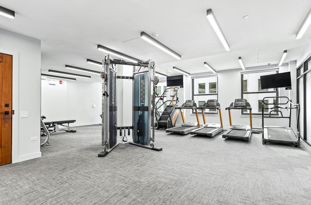 a gym with cardio equipment and weights in a building