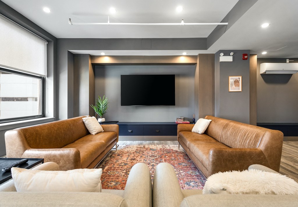 a living room with two couches and a tv on the wall