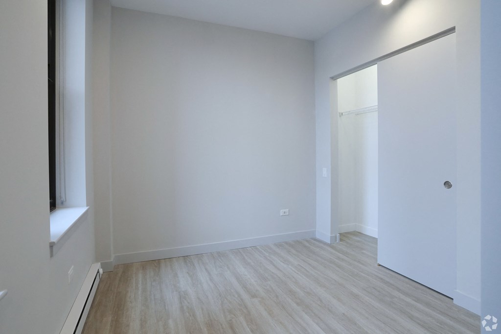 an empty room with white walls and a sliding glass door