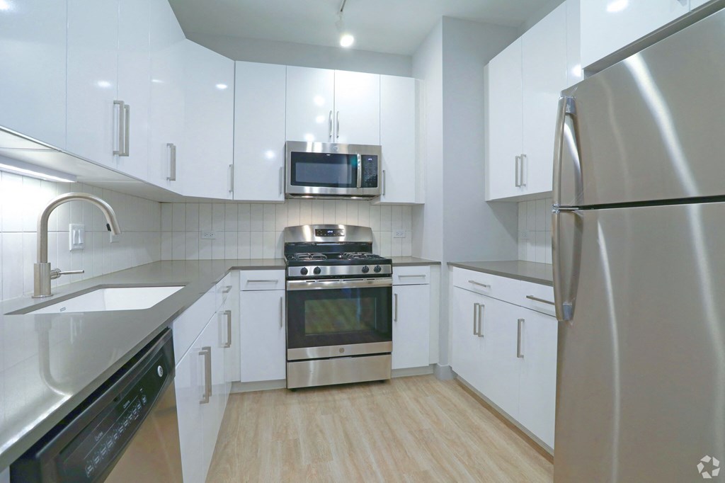 a kitchen with white cabinets and stainless steel appliances