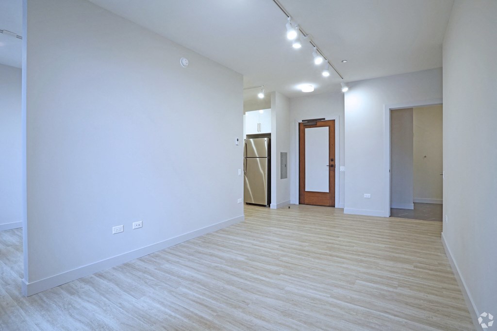 an empty living room with white walls and wood flooring