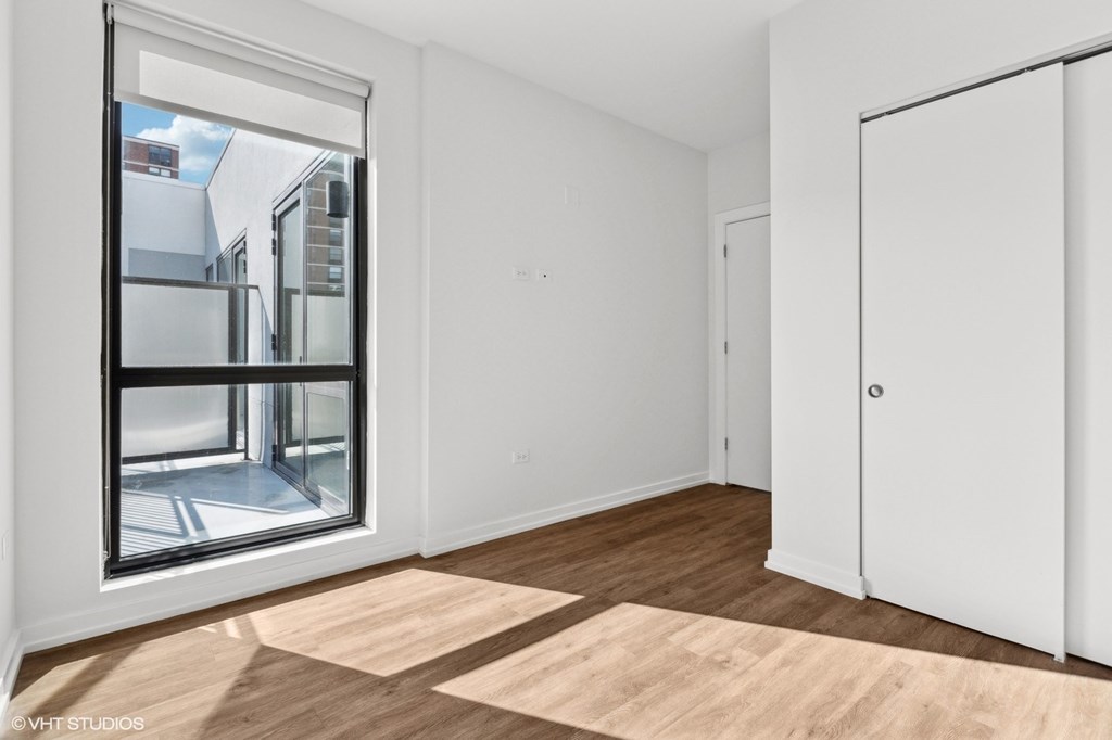 A room with a large window and wooden flooring.