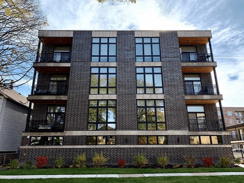 A modern brick building with large windows and balconies.