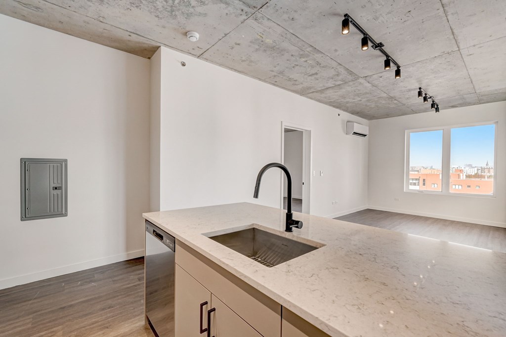 A kitchen with a sink and a window overlooking a cityscape.
