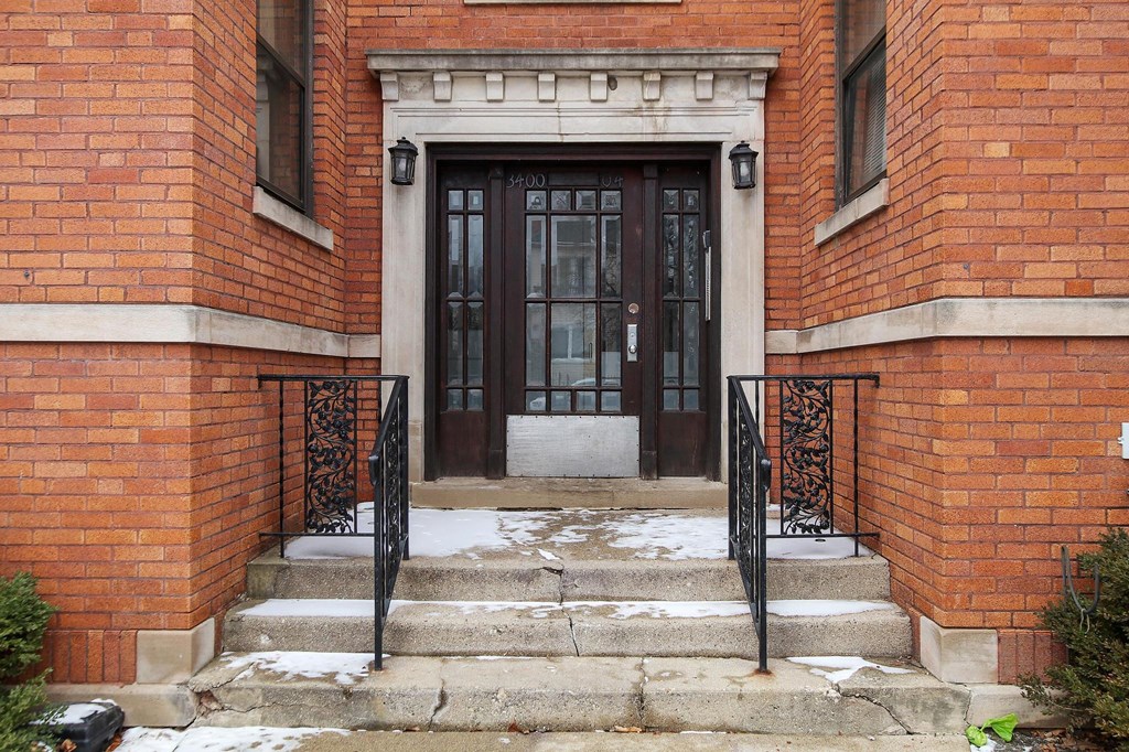 the front door of a brick building with a black door