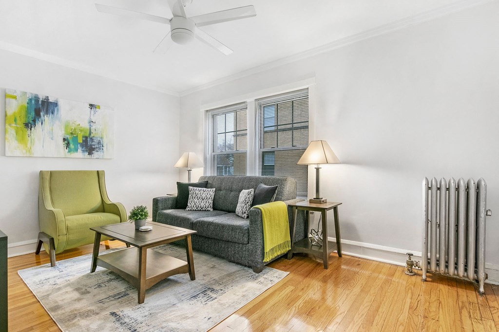 a living room with a couch and a chair and a ceiling fan
