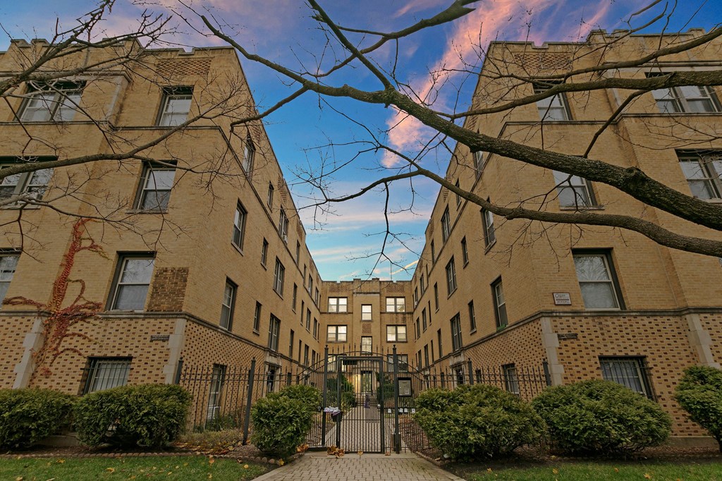 a courtyard between two brick buildings with a blue sky
