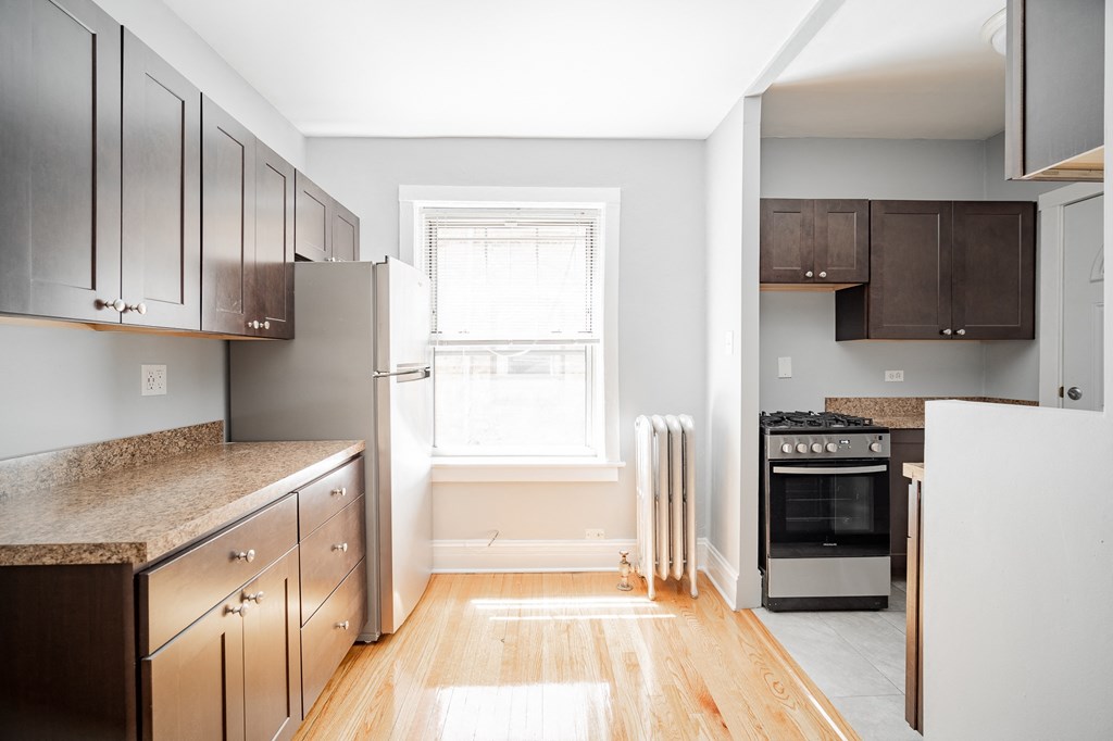 a kitchen with wooden cabinets and stainless steel appliances and a window