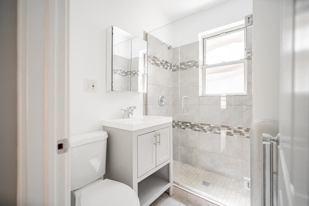 a white bathroom with a shower sink and toilet