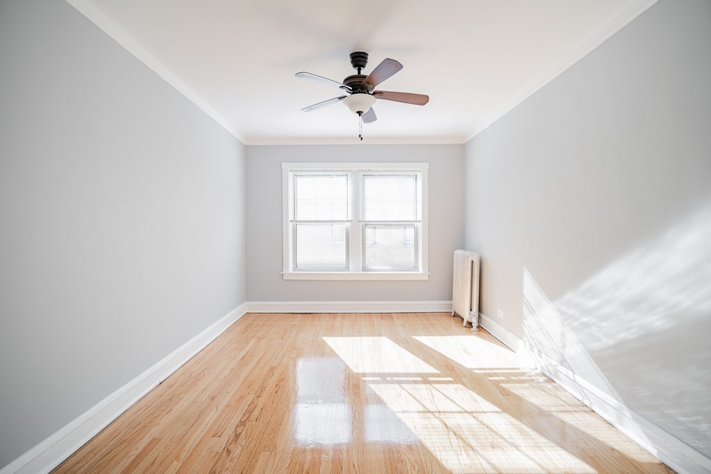 an empty room with a ceiling fan and a window