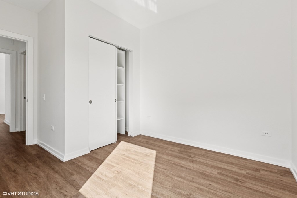 A room with a white door and a wooden floor.
