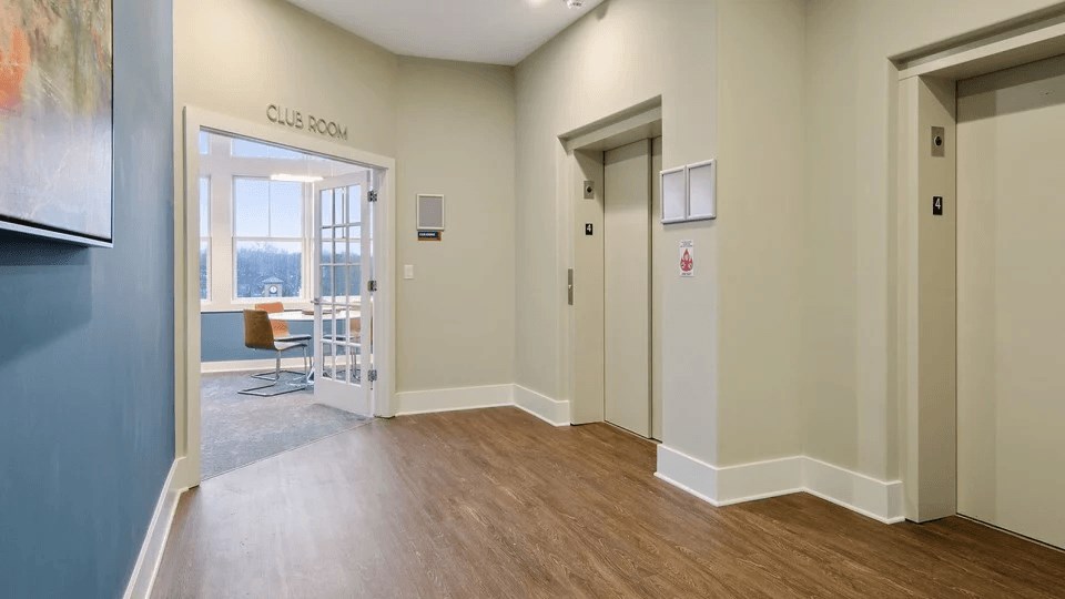 A hallway with a club room sign on the door.