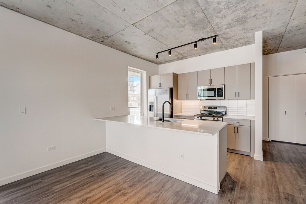 A kitchen with a white island and stainless steel appliances.
