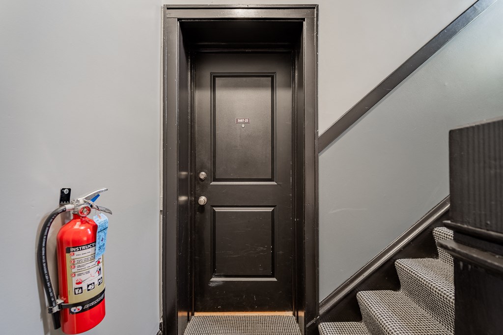 the door to the stairwell with a fire hydrant and a fire extinguisher