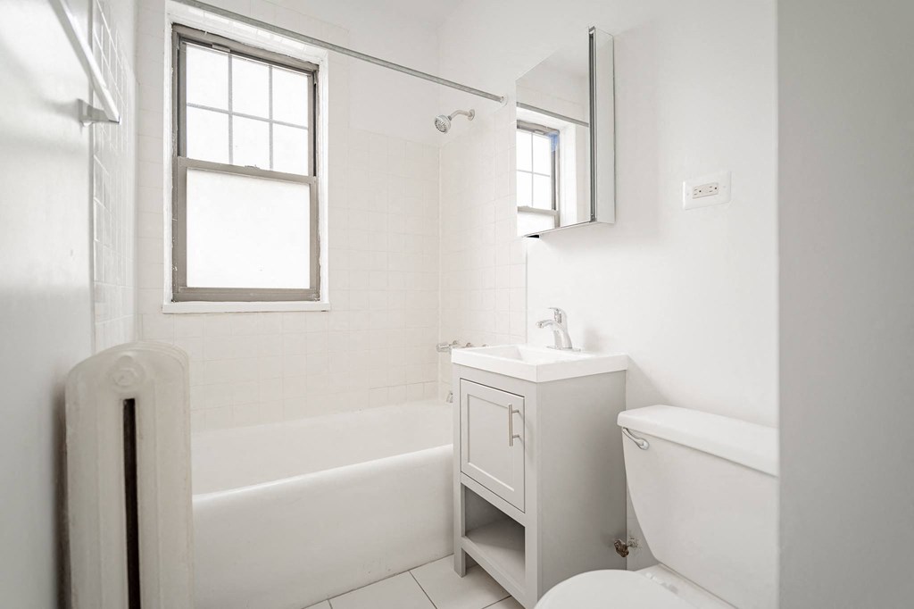 a white bathroom with a tub and a sink