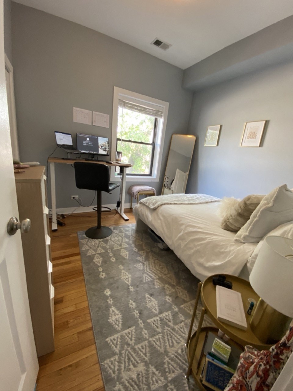 a bedroom with a bed and a desk and a window