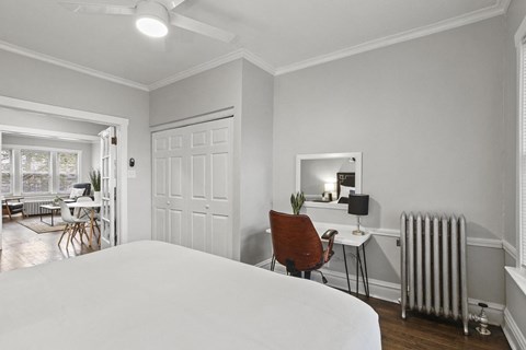 a bedroom with a bed and a desk and a radiator
