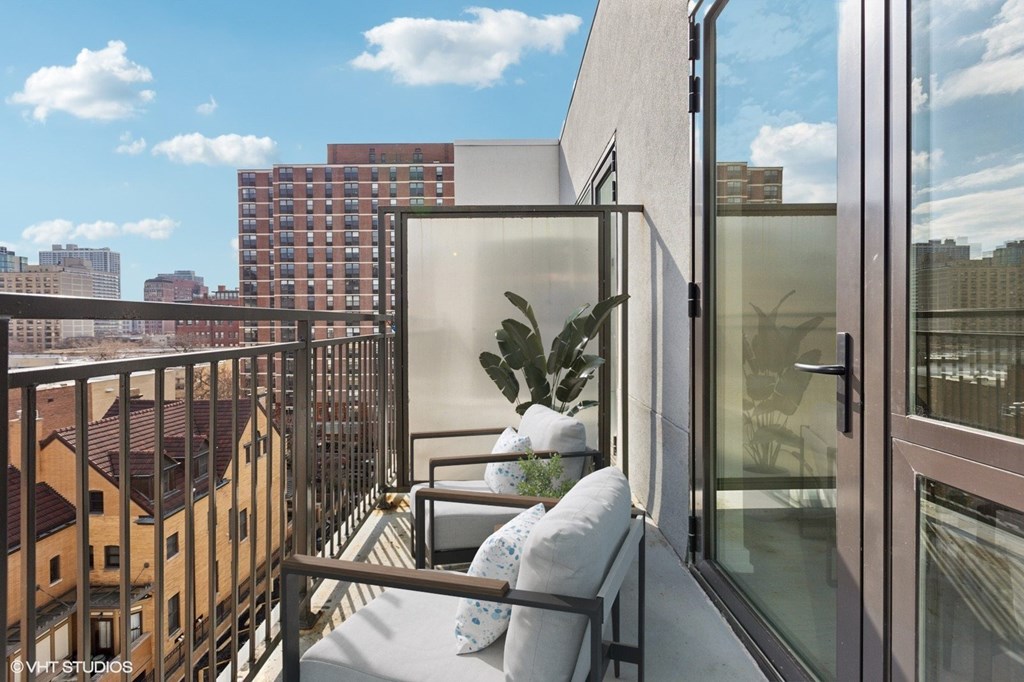 A balcony with a white cushion and a plant on it.