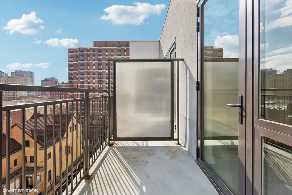 A balcony with a glass door and a metal railing.