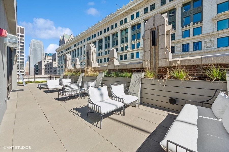 a roof deck with lounge chairs and a view of the city