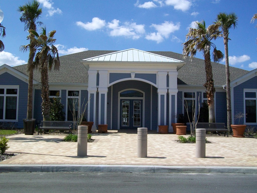A building with a blue and white facade is surrounded by palm trees.
