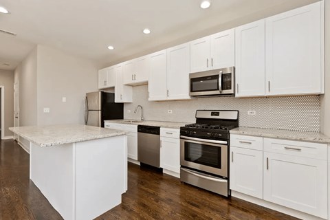 A kitchen with white cabinets and stainless steel appliances.