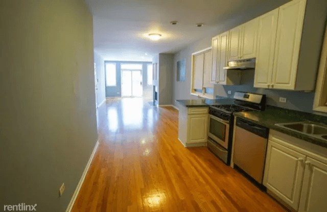 an empty kitchen and living room with a wood floor