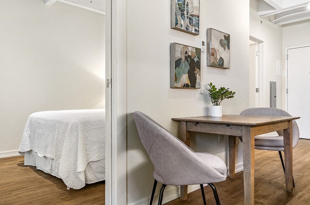 a bedroom with a desk and chair and a bed in a room with a mirror